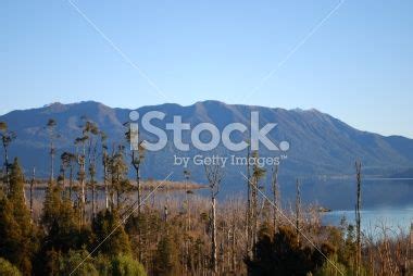 The Mountains Are In The Distance With Water And Trees