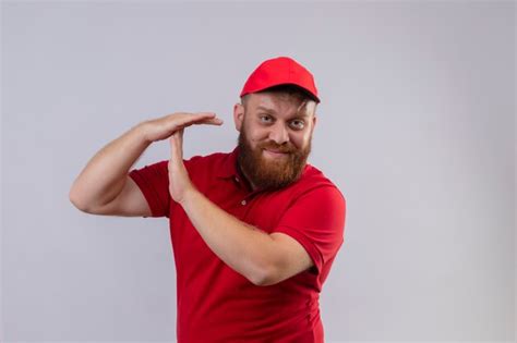 Jovem barbudo entregador de uniforme vermelho e boné parecendo cansado