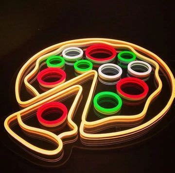 a pizza shaped neon sign sitting on top of a black table with red ...