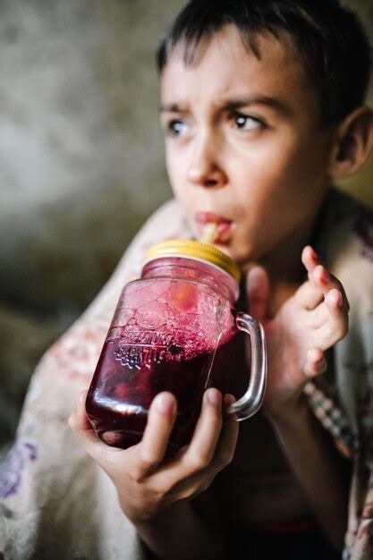 Premium Photo Boy Drinking Juice In Container