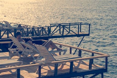 Premium Photo Deck Chairs On A Wooden Platform On The Beach