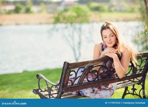 Young Beautiful Woman Sitting On Bench In Park Pretty Girl At Outdoors