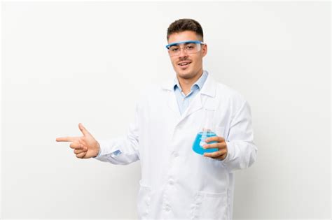 Joven científico sosteniendo frasco de laboratorio sobre pared