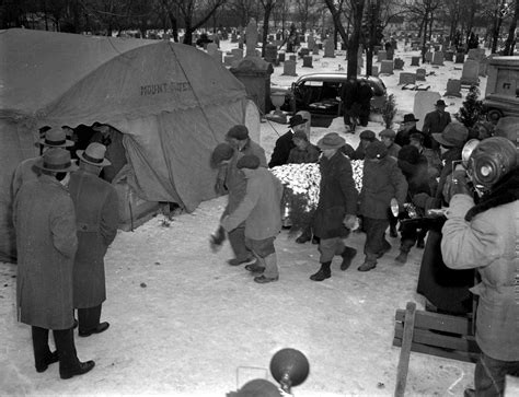 Original Chicago | Gravediggers carry the coffin containing the body of