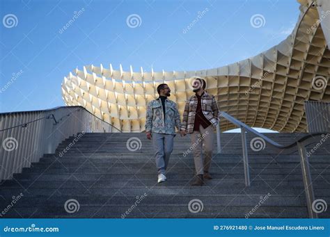 Una Joven Pareja Gay Casada Está Bajando Por Una Escalera Sosteniéndose De La Mano Mientras