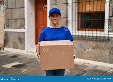 Middle Age Brunette Woman Working Delivering Big Package Depressed And