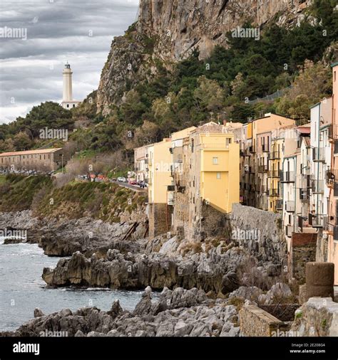 Old Stone Houses And Lighthouse On The Rocky Coast Of Cefalu Town In