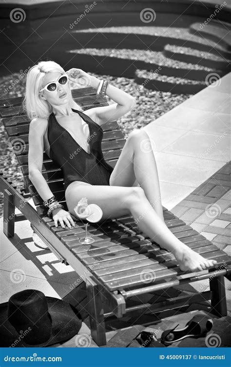 Beautiful Sensual Blonde With Fashionable Sunglasses Relaxing At Swimming Pool With A Juice