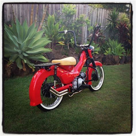 A Red Motorcycle Parked On Top Of A Lush Green Field