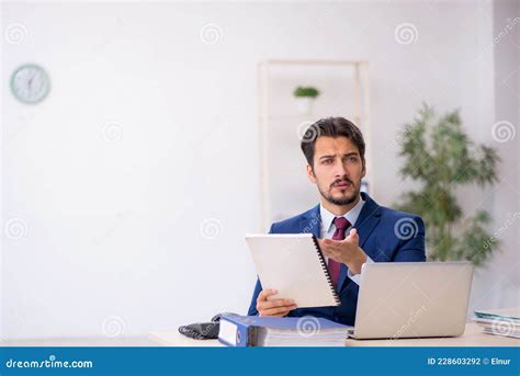 Un Joven Empleado De Sexo Masculino Leyendo Papel En El Lugar De