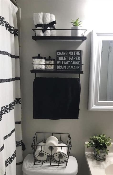 A White Toilet Sitting Next To A Sink In A Bathroom With Black And