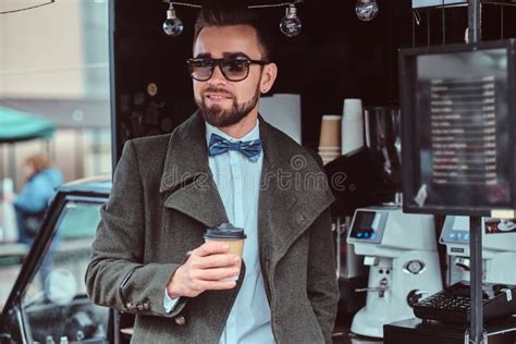 Modern Smiling Man In Sunglasses Is Drinking Coffee While Standing