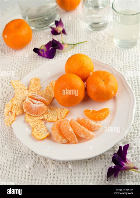 Whole And Peeled Mandarin Oranges On A Plate With Refreshments In The