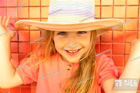 Happy Cute Girl Wearing Hat In Front Of Wall Stock Photo Picture And