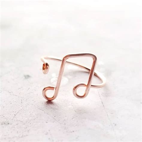 A Music Note Shaped Ring Sitting On Top Of A White Surface With A Tiny