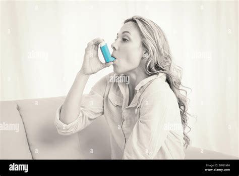 Blonde Using Her Asthma Inhaler On Couch Stock Photo Alamy