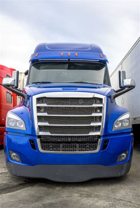 Bright Blue Big Rig Semi Truck With Chrome Grille Standing In Row With