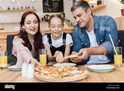 Familia feliz comiendo pizza Fotografía de stock Alamy