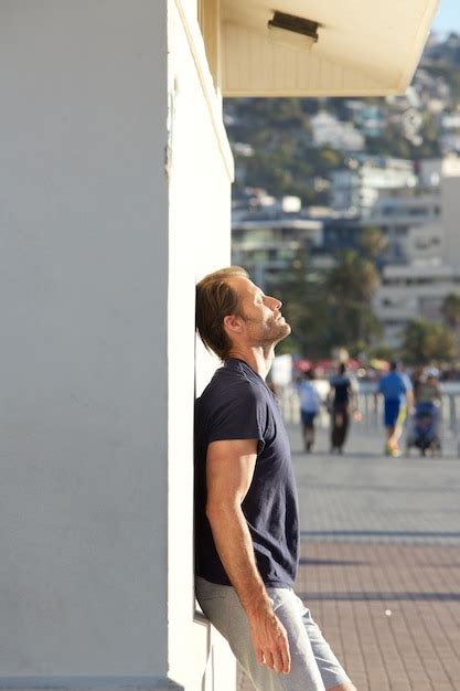 Premium Photo Tired Fitness Man Leaning Against Wall