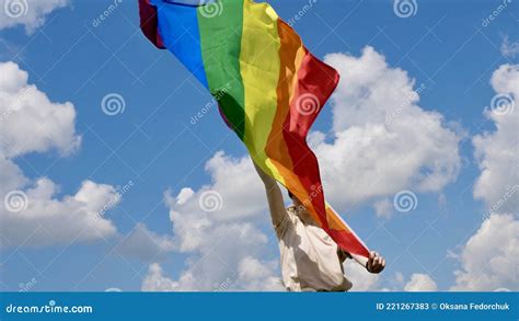 Person Holding Lgbt Flag On Sky Cloudy Background Stock Image Image