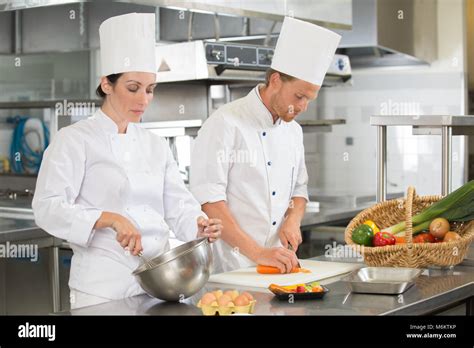 Man And Woman Chefs Cooking Food At Restaurants Kitchen Stock Photo Alamy