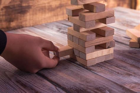 La Mano Del Primer Toma Un Bloque En Una Torre De Bloques De Madera