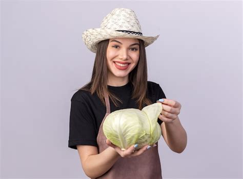 Souriante jolie jardinière caucasienne portant un chapeau de jardinage