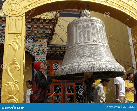 A Man Prays Next To A Large Bell At The Boudhanath Stupa In Kathmandu