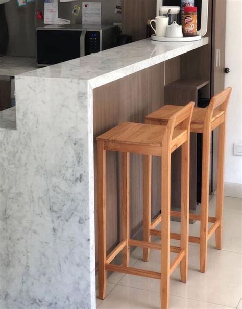 Two Wooden Stools Sitting In Front Of A Marble Counter Top Next To A