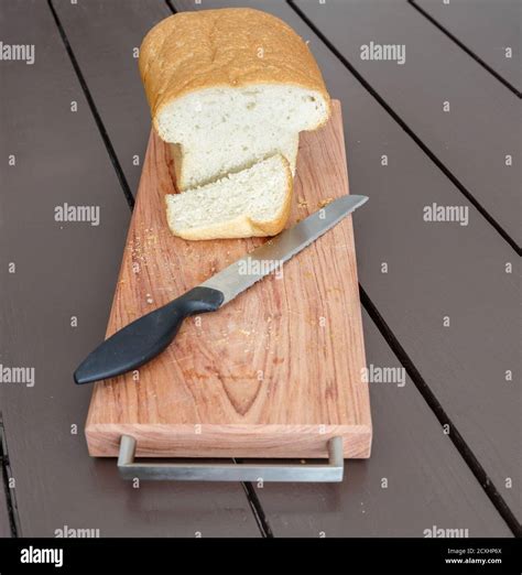 Loaf Of Fresh White Bread With Cut Slice On Smart Breadboard With Black