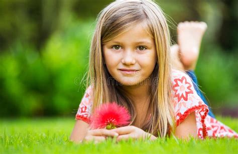 Retrato De Una Niña Sonriente Que Miente En Hierba Verde Foto de