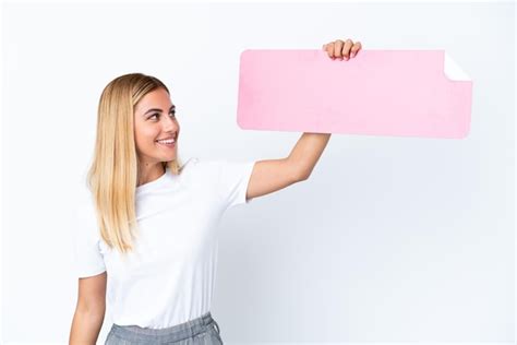 Fille uruguayenne blonde isolée sur fond blanc tenant une pancarte vide Photo Premium