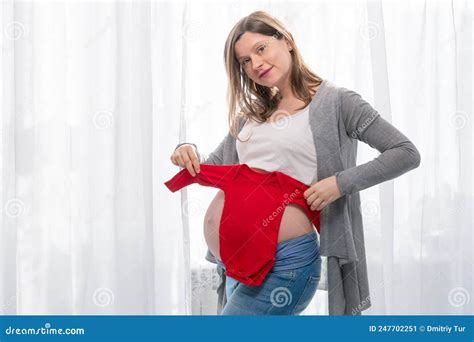 Pregnant Woman With Big Belly Trying Red Bodysuits On Her Belly