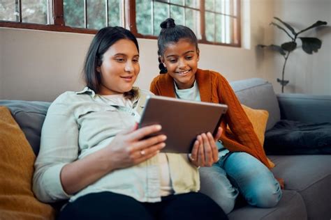 Tablet mãe grávida e menina assistindo desenhos animados e filmes