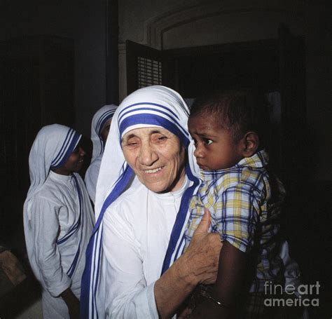 Mother Teresa Holding Young Boy by Bettmann