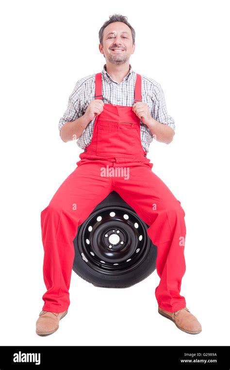 Proud Mechanic Sitting On Car Wheel Tire Isolated On White Stock Photo