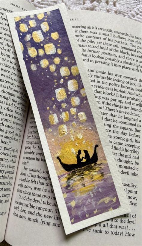 An Open Bookmark With Two People In A Boat Floating On The Water At Night