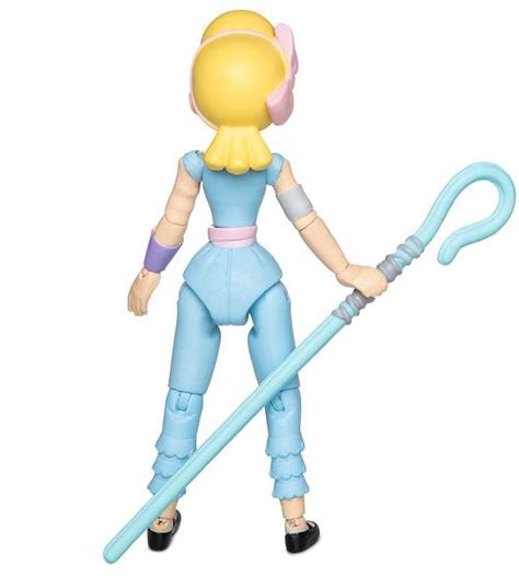 An Action Figure Is Holding A Large Blue Object In Her Hand And Wearing A Pink Outfit