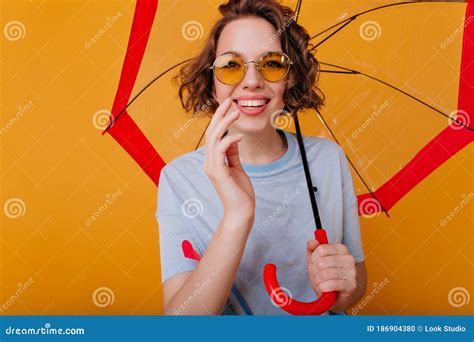 Dark Haired Cheerful Girl In Yellow Sunglasses Smiling To Camera