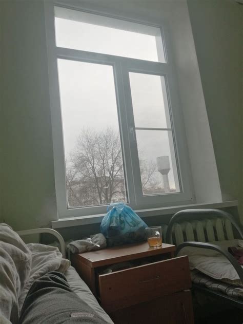 A Bedroom With A Bed Chair And Window In The Corner On A Foggy Day