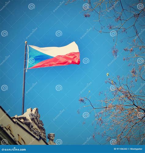 The Flag of the Czech Republic on a Building with Blue Sky and the Sun