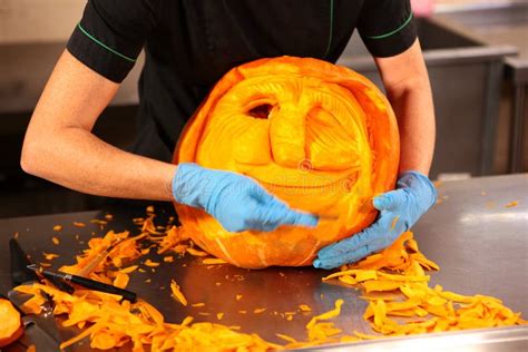 Carving Pumpkins For Halloween Womenand X27s Gloved Hands Carve A Scary Face Out Of A Pumpkin