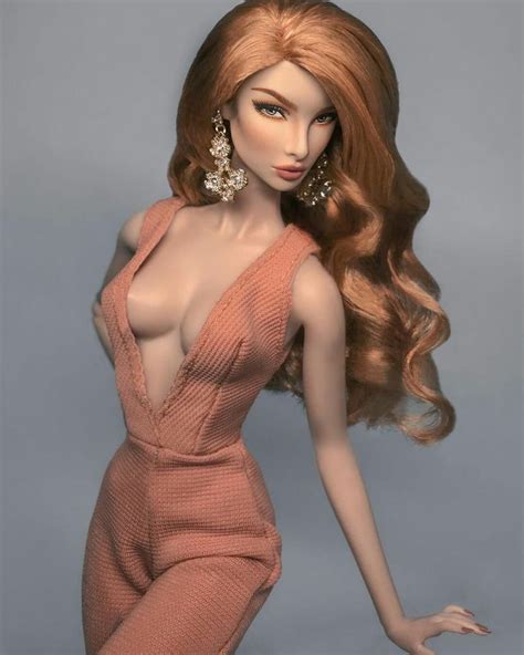 A Barbie Doll With Long Red Hair Wearing A Pink Dress And Gold Earrings