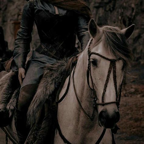 a woman riding on the back of a white horse