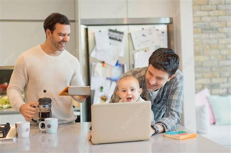 Male Gay Parents And Baby Son Using Laptop Stock Image F