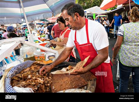 Un carnicero mexicano recién chuletas de cerdo a la barbacoa carnitas