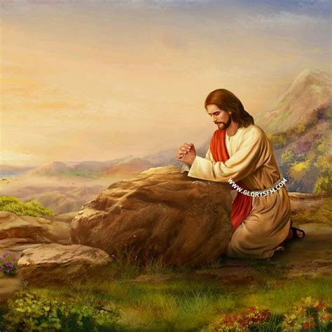 Jesus Sitting On A Rock With His Hands Folded In Prayer And Looking At