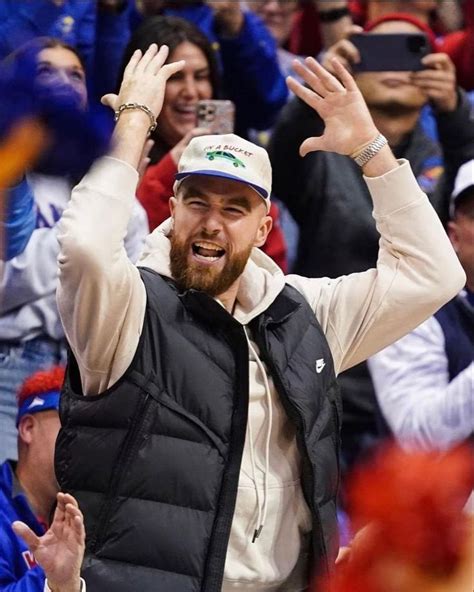 a man with his hands up in the air at a basketball game while people ...