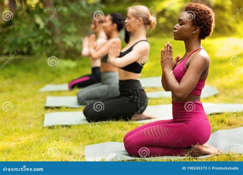 Yoga For Inner Balance Group Of Diverse Women Meditating At Park Blank Space Stock Image