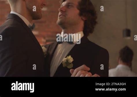 Tilt Down Slowmo Of Affectionate Gay Couple In Black Tuxedos Holding